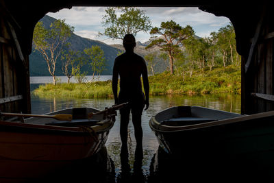 Rear view of man standing in boat