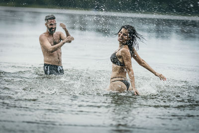 Happy mature man and woman having fun together in lake