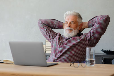 Portrait of man using laptop while sitting on table