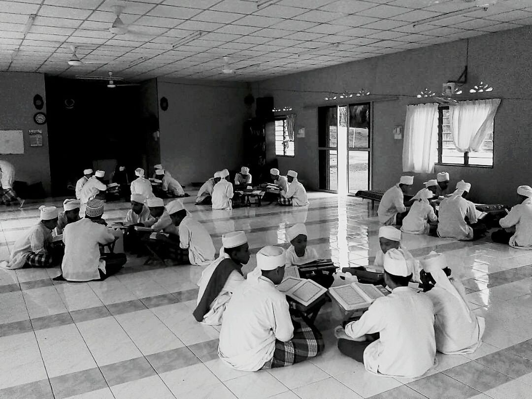 GROUP OF PEOPLE SITTING ON TILED FLOOR IN KITCHEN