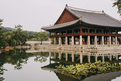 Building by lake against sky