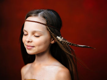 Portrait of beautiful young woman over red background