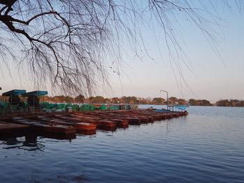 Boats moored in lake against clear sky