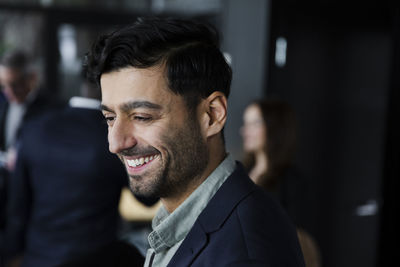 Bearded businessman smiling during seminar at conference center