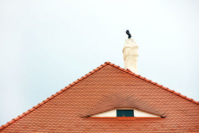 Low angle view of bell tower on roof of building against clear sky