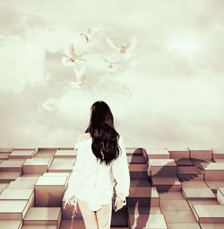 Rear view of woman standing against sky