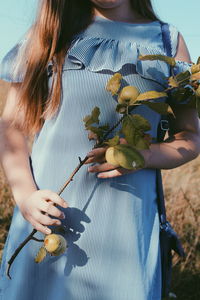 Midsection of woman holding fruit