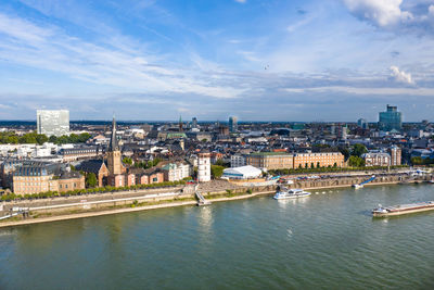 River amidst buildings in city against sky