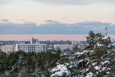 Buildings in city against sky during winter