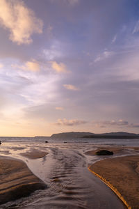 Scenic view of beach against sky during sunset