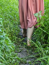 Low section of woman standing on field