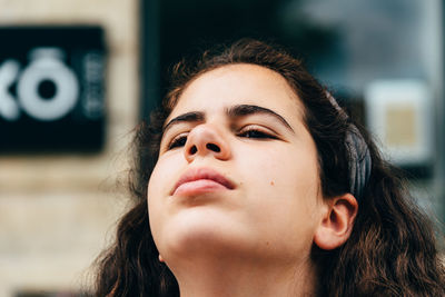 Close-up of teenage girl looking away in city