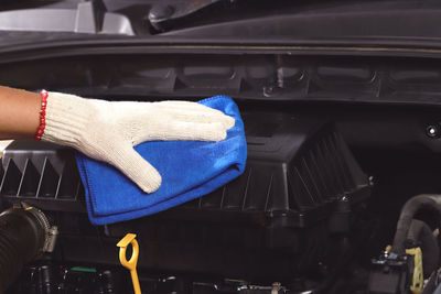 Cloth worker cleaning the car engine room