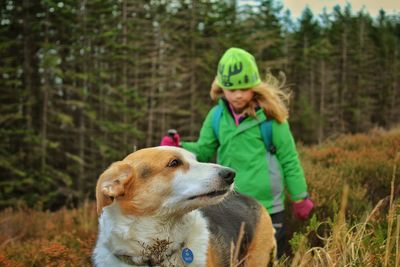 Girl with dog hiking at forest