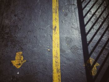 High angle view of yellow arrow symbols on road