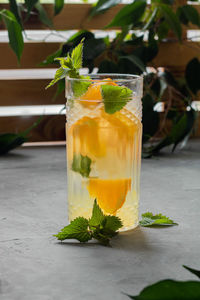 Glass with refreshing orange drink.   mineral water with pieces of fresh orange and mint.