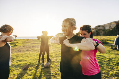 Team assisting each other during group training session at beach