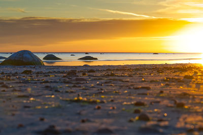 Surface level of sea against sky during sunset