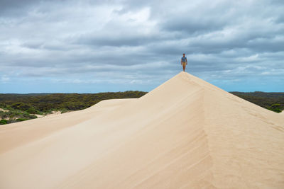 Scenic view of desert against cloudy sky