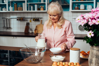 Smiling senior woman making cupcakes