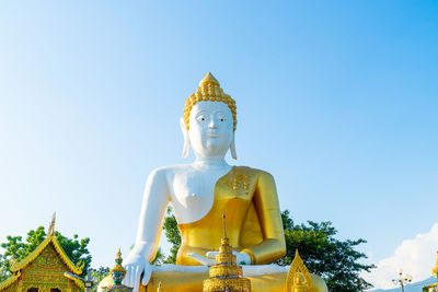 Low angle view of statue against temple against clear sky