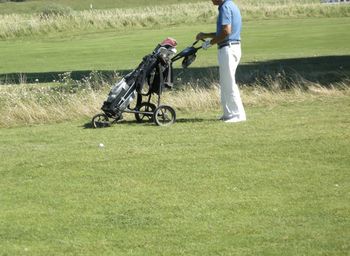 Low section of man with golf bag on field