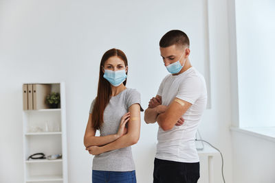 Young couple standing against wall