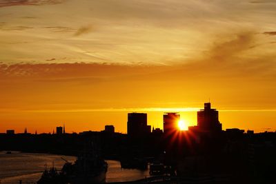 Silhouette buildings against romantic sky at sunset