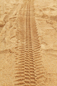 Full frame shot of tire tracks on sand