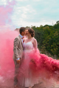 Rear view of couple standing against pink wall