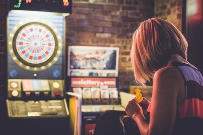 Rear view of girl playing darts 