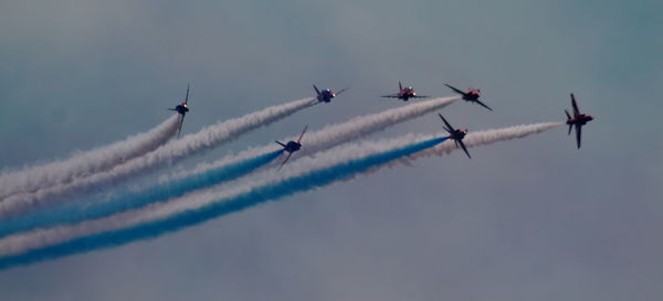 Low angle view of fighter planes performing airshow in sky
