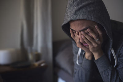 Portrait of sad man facing depression with hands covering his face