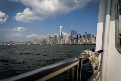 City at waterfront against cloudy sky