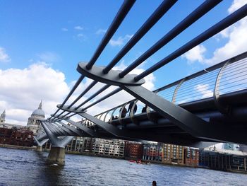 Low angle view of bridge over river against sky in city