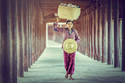 Full length portrait of woman standing on wood