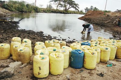 Woman filling plastic container from lake