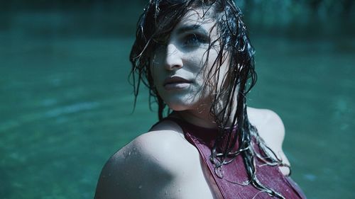 Close-up of wet beautiful woman standing in lake