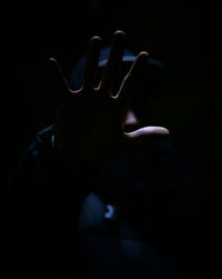 Close-up of human hand against black background