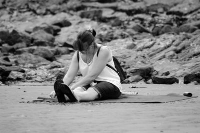 Young woman sitting on land at beach