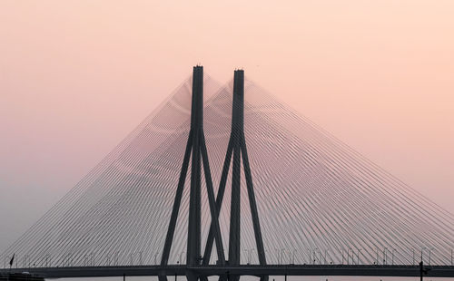 Low angle view of suspension bridge against sky during sunset