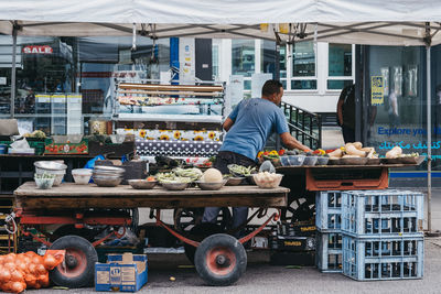 Rear view of man for sale at market stall