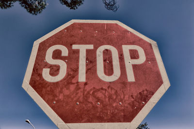 Low angle view of road sign against blue sky