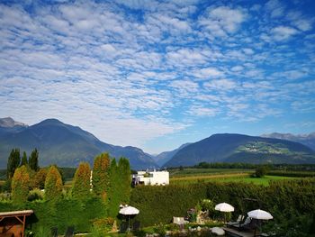 Houses on field by mountains against sky