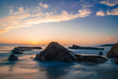 Scenic view of beach against sky during sunset