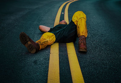 Full length of man lying down on road