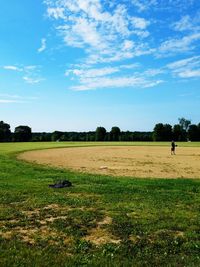 Man on grassy field against sky