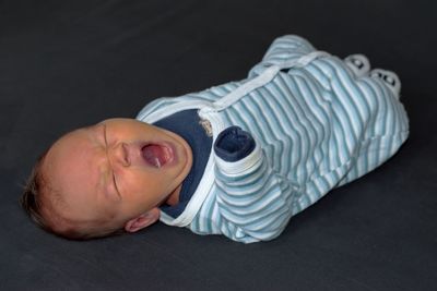 Closeup of cute newborn baby lying on black background