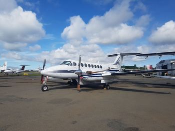 Airplane on airport runway against sky