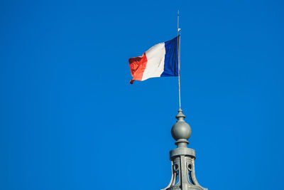 Low angle view of flag against blue sky